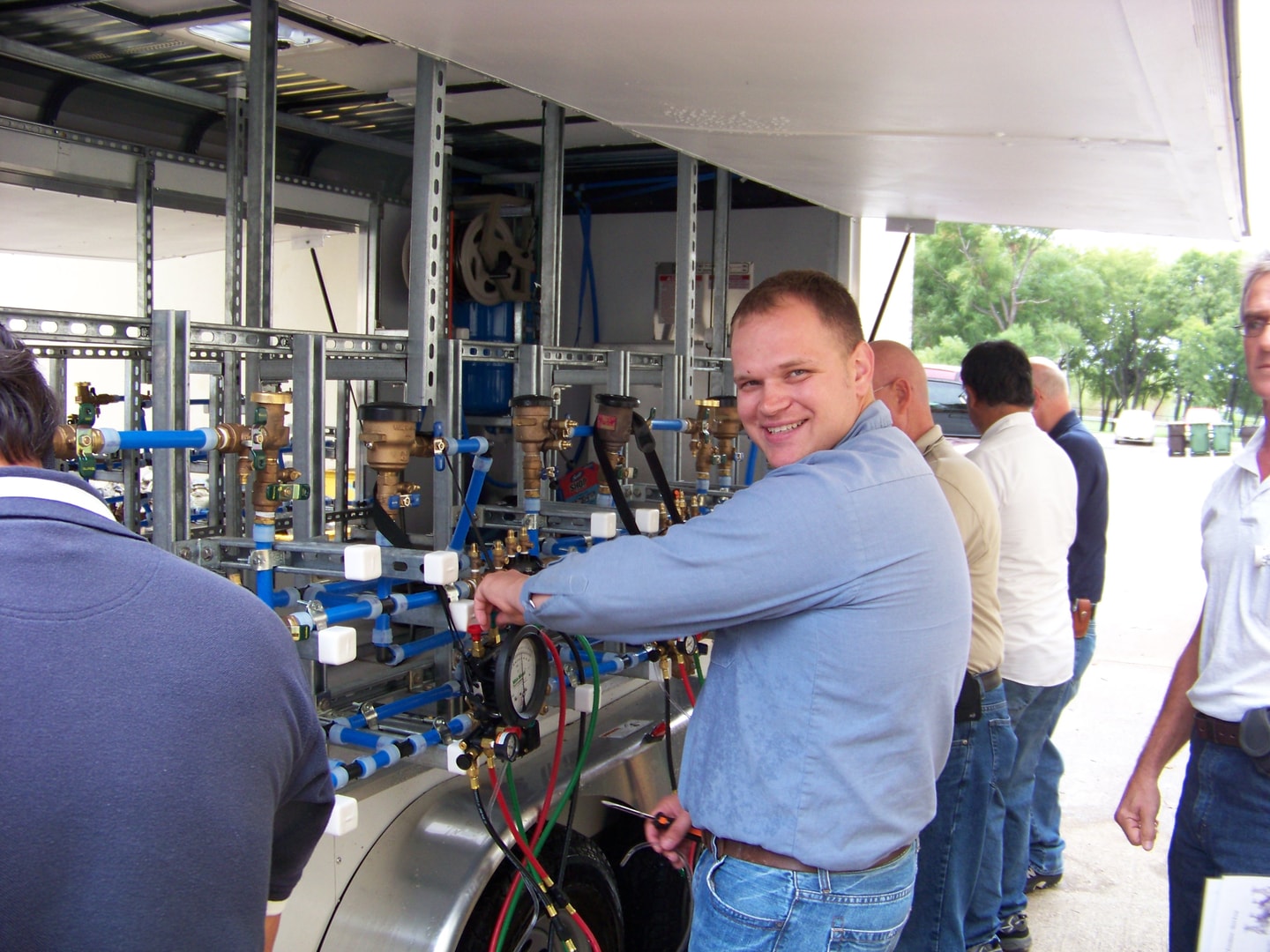 Group examining hydraulic equipment during industrial training